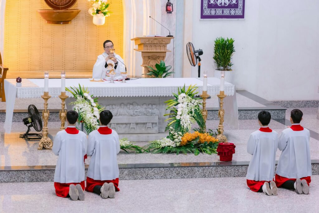 Priest conducting a religious ceremony with altar boys kneeling, showcasing a sacred moment.